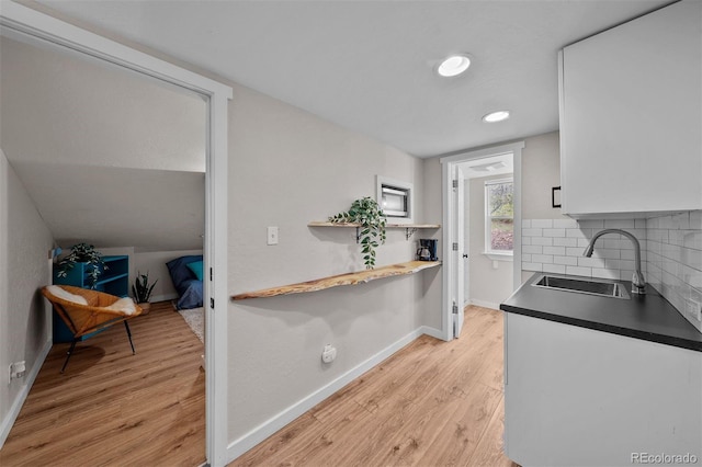 245 N County Highway 67, Sedalia, CO 80135 - kitchen with light wood-type flooring, backsplash, dark countertops, white cabinets, and recessed lighting