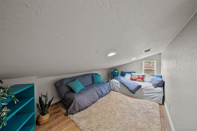 245 N County Highway 67, Sedalia, CO 80135 - bedroom with a textured ceiling, wood finished floors, and vaulted ceiling