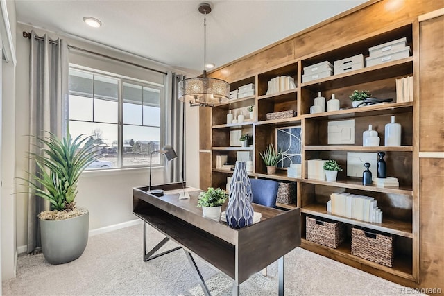 carpeted office space featuring a chandelier