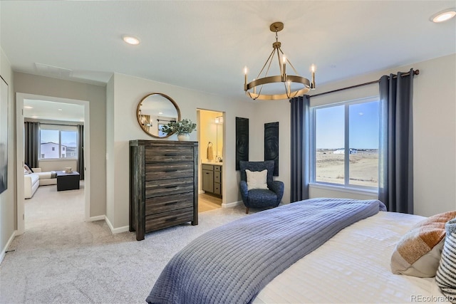 bedroom with ensuite bath, light colored carpet, and a notable chandelier