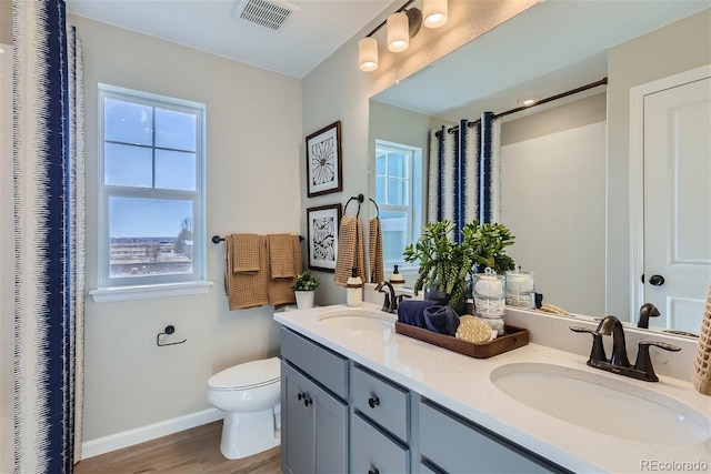 bathroom featuring vanity, toilet, wood-type flooring, and walk in shower