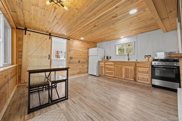 15535 S Elk Creek Rd, Pine, CO 80470 - kitchen with stainless steel gas range, freestanding refrigerator, wood ceiling, wood walls, and a sink