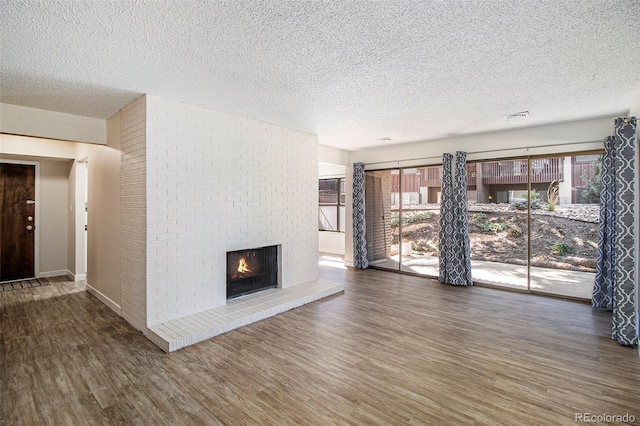 500 Manhattan Dr Unit B1, Boulder, CO 80303 - unfurnished living room with a textured ceiling, wood finished floors, and a fireplace