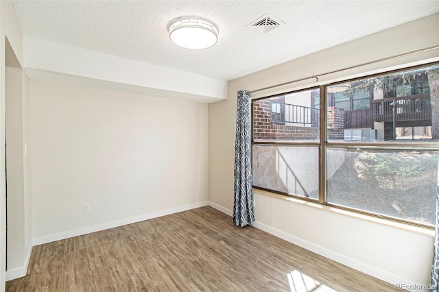 500 Manhattan Dr Unit B1, Boulder, CO 80303 - spare room with wood finished floors, baseboards, and a textured ceiling