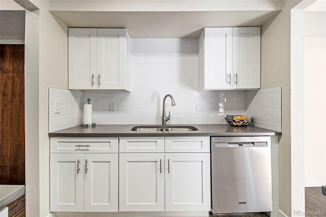 500 Manhattan Dr Unit B1, Boulder, CO 80303 - kitchen with stainless steel dishwasher, a sink, dark countertops, tasteful backsplash, and white cabinets