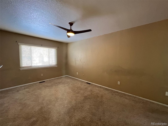 carpeted spare room with ceiling fan and a textured ceiling