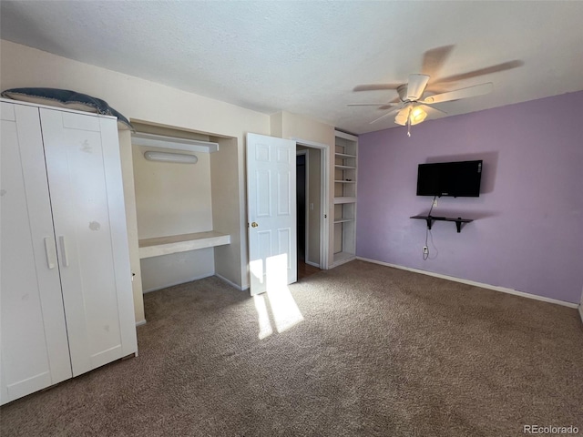 unfurnished bedroom featuring dark carpet and ceiling fan