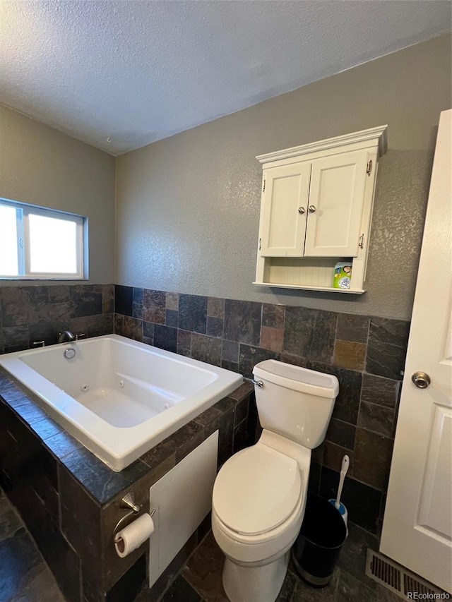 bathroom featuring tile walls, toilet, tile floors, and a bathtub