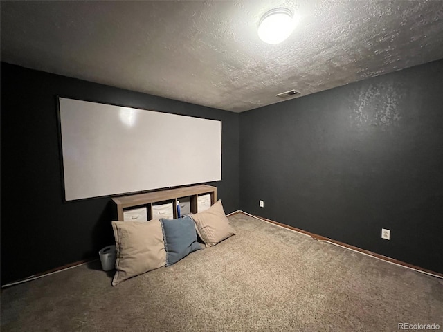 cinema room featuring dark colored carpet and a textured ceiling