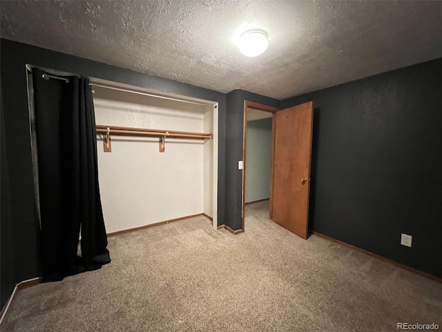 unfurnished bedroom with a textured ceiling, carpet, and a closet