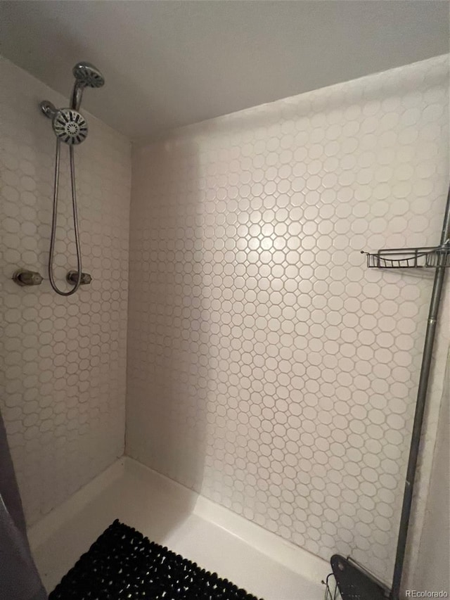 bathroom with tile floors and a tile shower