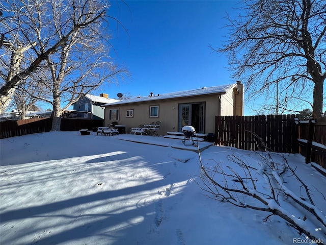 view of snow covered rear of property