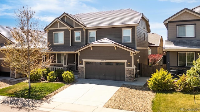 craftsman house with a garage, fence, covered porch, stone siding, and driveway