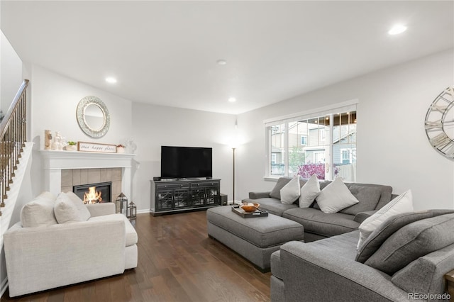 living room with a fireplace, recessed lighting, stairs, and dark wood-type flooring