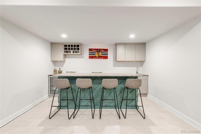 bar with baseboards, indoor wet bar, and recessed lighting