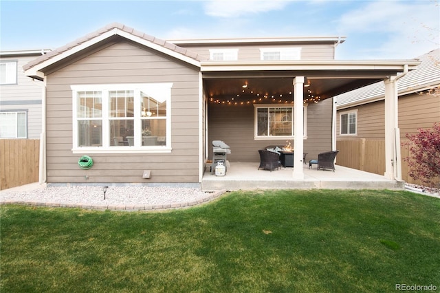 back of property with a lawn, fence, and a patio area