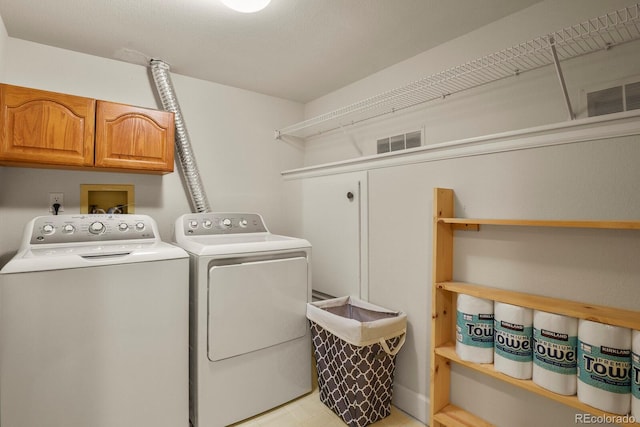 laundry room with cabinets and washer and dryer