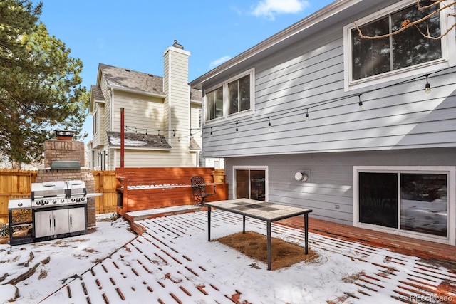 snow covered rear of property featuring a fireplace and a deck