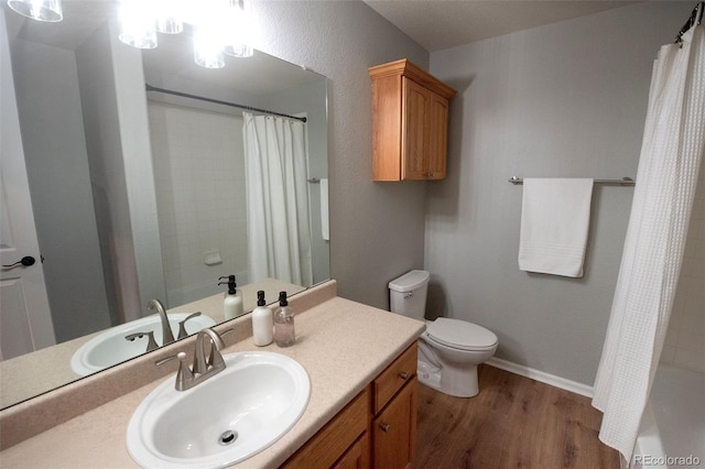 full bathroom featuring toilet, vanity, wood finished floors, a shower with curtain, and baseboards