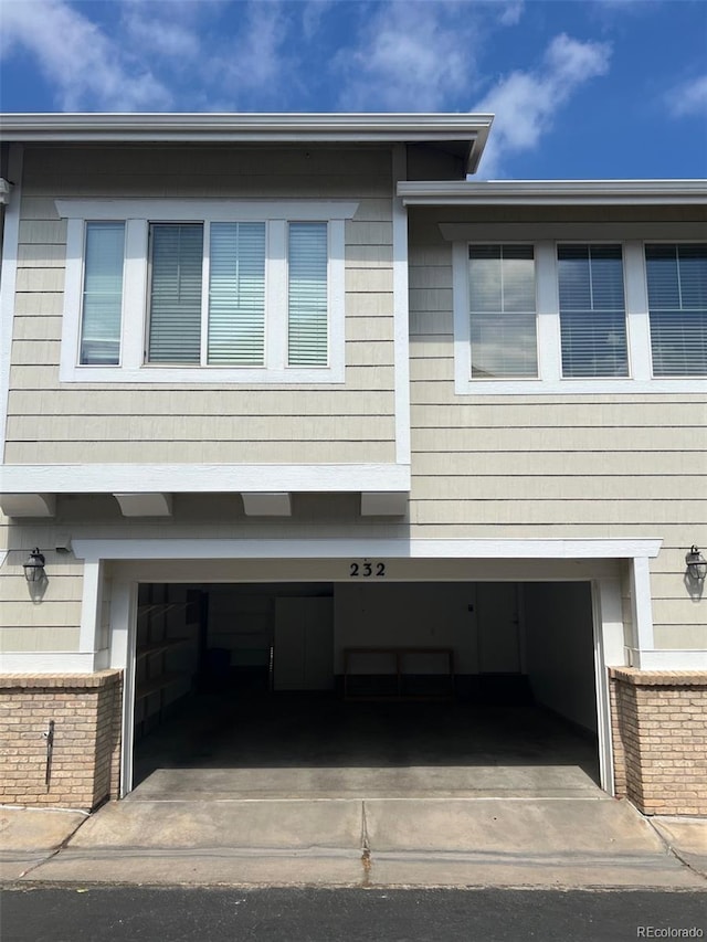 view of property exterior featuring a garage, driveway, and brick siding