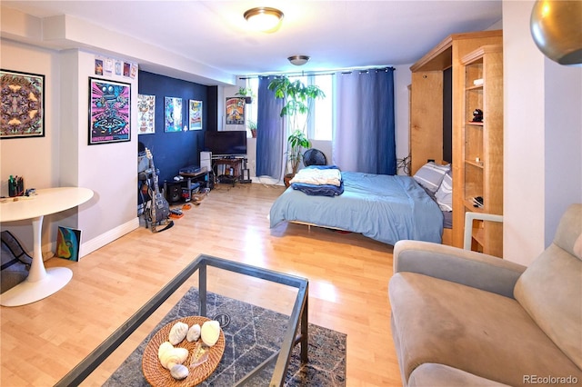 bedroom featuring baseboards and wood finished floors