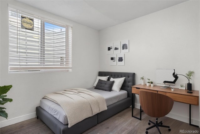 bedroom featuring baseboards and wood finished floors