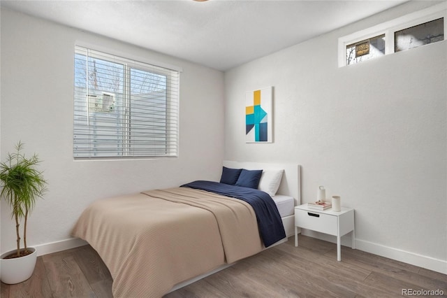 bedroom with baseboards and wood finished floors