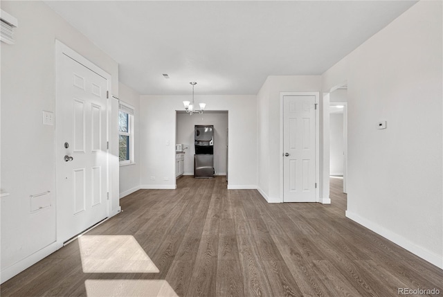 entryway with a chandelier, dark wood-style flooring, and baseboards