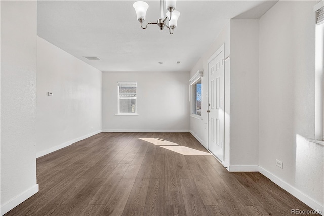 entryway featuring dark wood-style floors, visible vents, baseboards, and an inviting chandelier