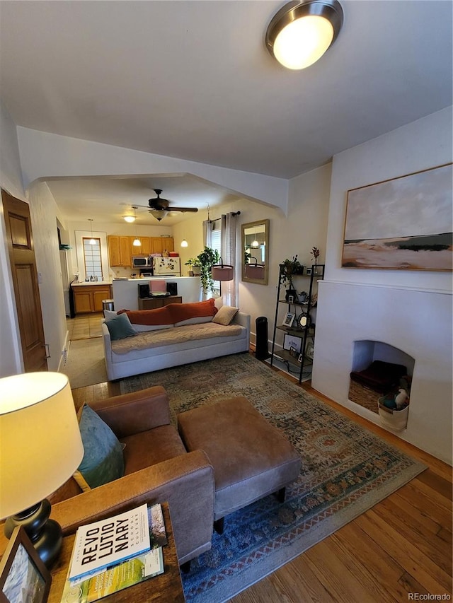 living area featuring light wood-style flooring and a ceiling fan