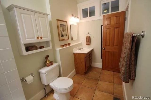 bathroom featuring tile patterned floors, vanity, baseboards, and toilet