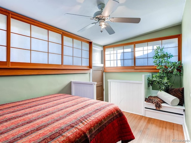 bedroom featuring hardwood / wood-style floors, a ceiling fan, and lofted ceiling