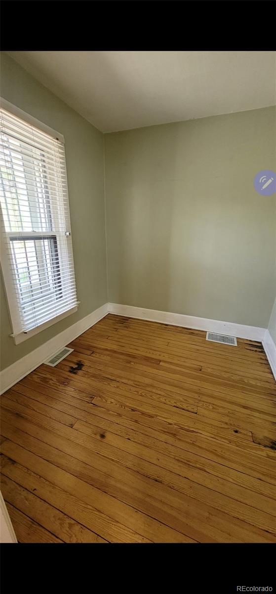 914 E Iowa Ave, Denver, CO 80210 - empty room featuring baseboards and hardwood / wood-style flooring