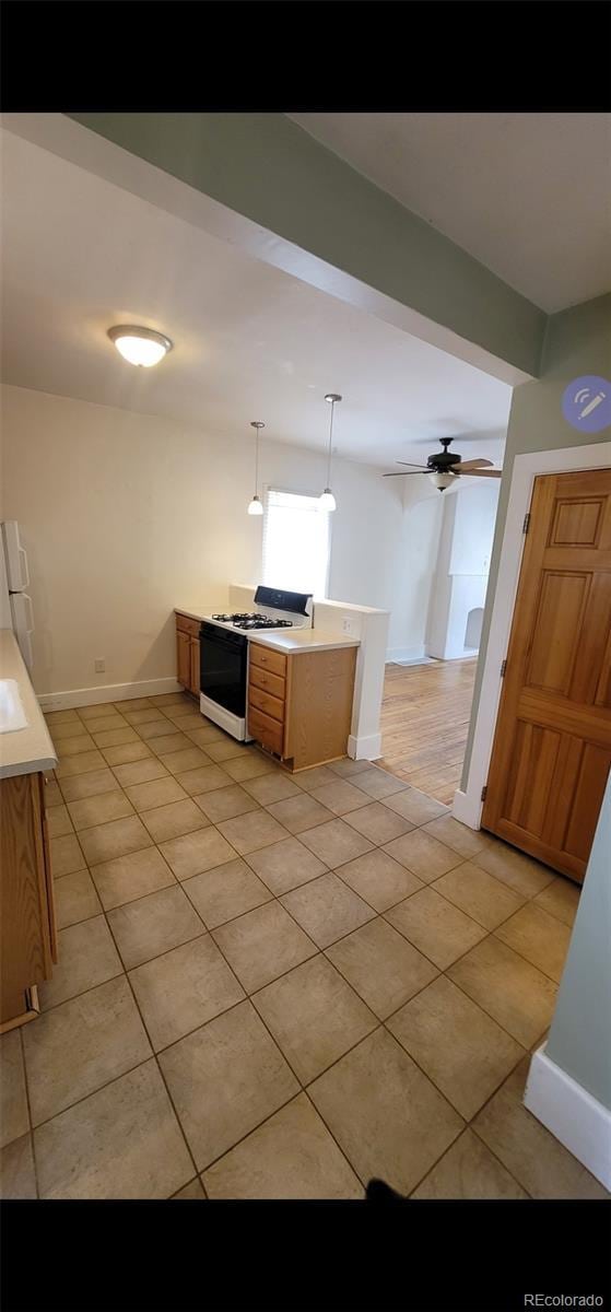 914 E Iowa Ave, Denver, CO 80210 - kitchen featuring white appliances, light tile patterned flooring, baseboards, a peninsula, and light countertops