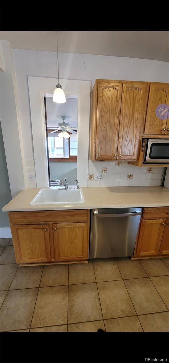 914 E Iowa Ave, Denver, CO 80210 - kitchen with stainless steel appliances, a sink, light tile patterned floors, and light countertops