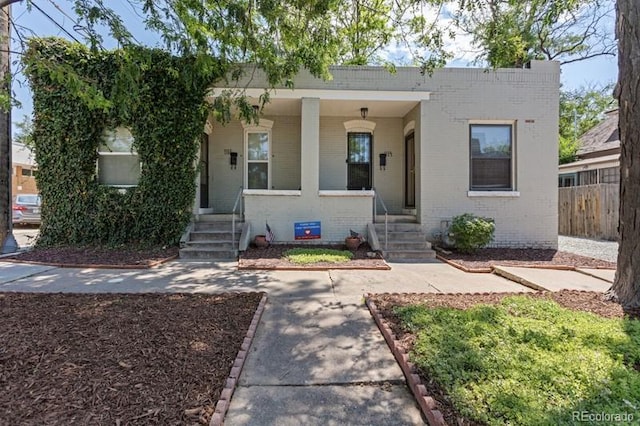 914 E Iowa Ave, Denver, CO 80210 - view of front facade with brick siding and a porch