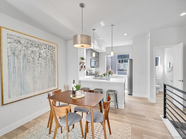 dining area with recessed lighting, light wood-style floors, and baseboards