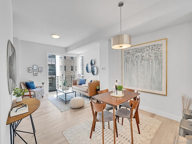 dining space featuring baseboards and light wood-style floors