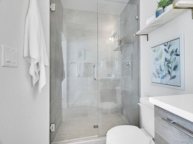 bathroom with vanity, toilet, and a shower stall