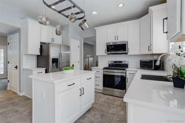 9954 Heywood St, Highlands Ranch, CO 80130 - kitchen with stainless steel appliances, a sink, tasteful backsplash, a kitchen island, and white cabinets