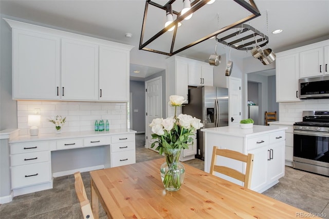 9954 Heywood St, Highlands Ranch, CO 80130 - kitchen featuring appliances with stainless steel finishes, light countertops, tasteful backsplash, white cabinetry, and a center island