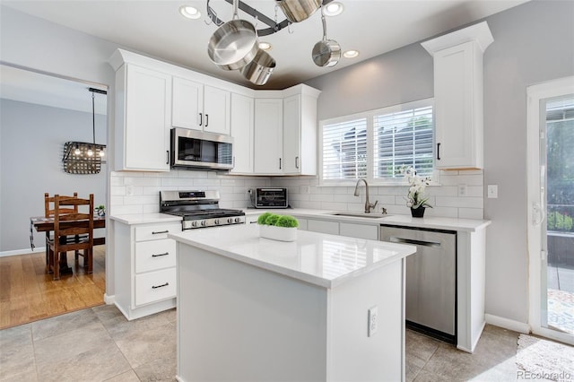 9954 Heywood St, Highlands Ranch, CO 80130 - kitchen featuring appliances with stainless steel finishes, a sink, decorative backsplash, light countertops, and white cabinetry