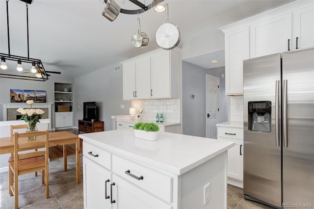 9954 Heywood St, Highlands Ranch, CO 80130 - kitchen featuring stainless steel refrigerator with ice dispenser, tasteful backsplash, pendant lighting, and white cabinetry