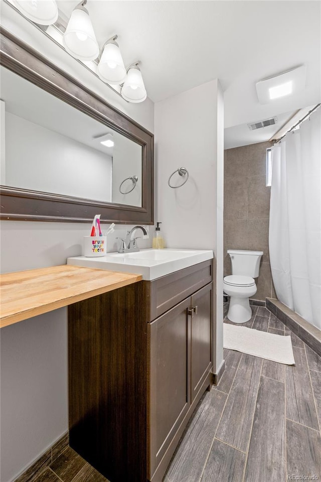 13402 W 24th Pl, Golden, CO 80401 - bathroom featuring vanity, wood finish floors, toilet, and curtained shower