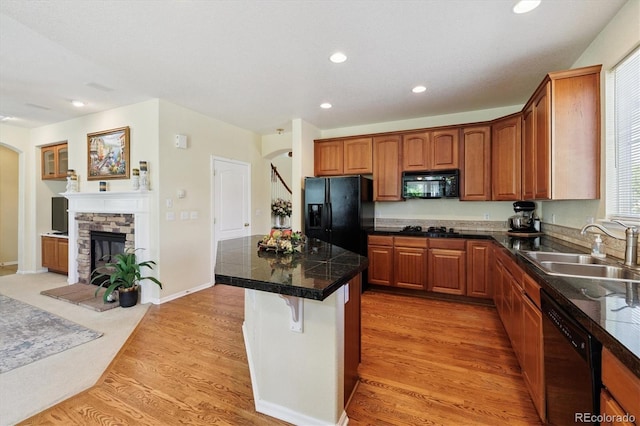 17298 E Lake Pl, Aurora, CO 80016 - kitchen featuring black appliances, tile counters, a kitchen island, light wood finished floors, and a kitchen breakfast bar