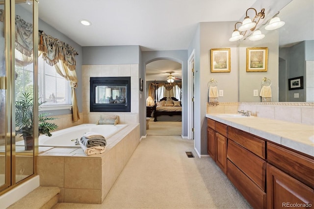 17298 E Lake Pl, Aurora, CO 80016 - ensuite bathroom with a garden tub, double vanity, a ceiling fan, and a fireplace