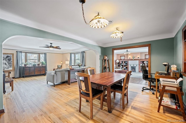 dining area with light wood-type flooring and ceiling fan