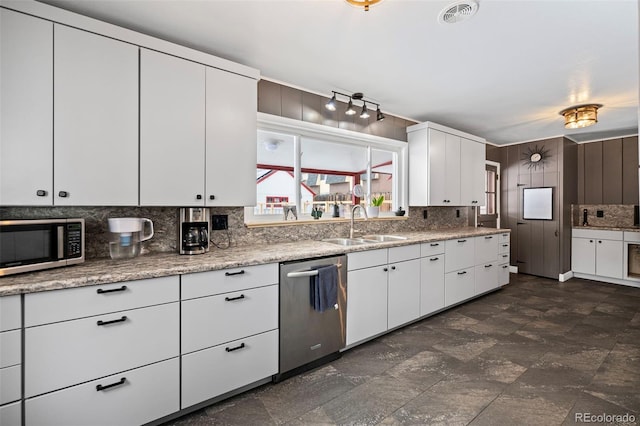 kitchen featuring sink, backsplash, white cabinetry, and appliances with stainless steel finishes