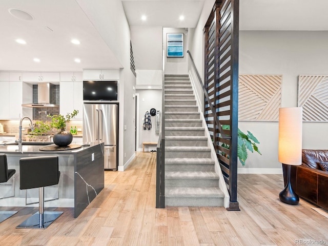 staircase with recessed lighting, wood finished floors, and baseboards