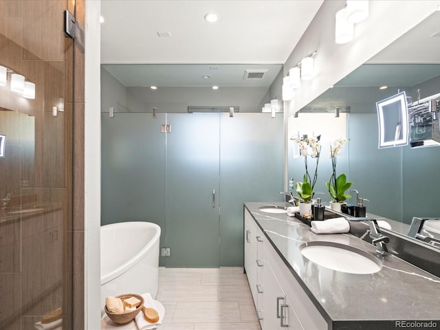 bathroom featuring a freestanding tub, a sink, visible vents, and a shower stall